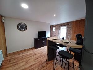 a room with a kitchen with a table and stools at Appartement T2 Rodez centre in Rodez