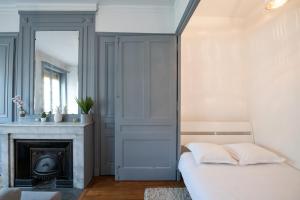 Un dormitorio con una cama y una chimenea. en Appartement de charme dans le 6e - central, en Gare des Brotteaux