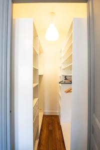 un vestidor con estanterías blancas y una luz en Appartement de charme dans le 6e - central, en Gare des Brotteaux
