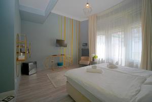 a bedroom with a large white bed and a window at W Urban Suites Budapest in Budapest +16 photos