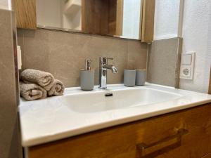 uma pia de banheiro com duas canecas em cima dela em Apartment Postplattler em Hof bei Salzburg mais 38 fotografias