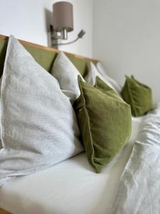 um sofá branco com almofadas verdes em Apartment Postplattler em Hof bei Salzburg