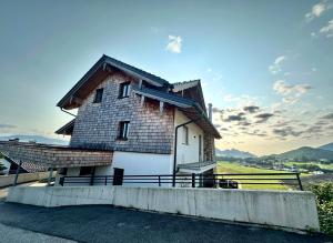 uma casa com um telhado no topo de uma colina em Apartment Postplattler em Hof bei Salzburg