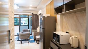 a kitchen with a refrigerator and a dining room at Baumanburi Hotel Patong in Patong Beach