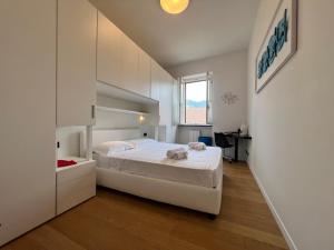 une chambre avec un grand lit blanc et une fenêtre dans l'établissement WELCOME RIVIERA - ORO Apartment, 2Bedroom, 2Bathroom Apartment with Free Garage at 800 mt, Lift, Shared Terrace, Balcony, Wi-Fi, Air Conditioning, The Ideal Choice for a Relaxing and Exciting Coastal Escape, à Rapallo