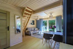 ミエルノにあるMi Casa Holidays Domki całoroczneのテーブルと椅子、リビングルームが備わる客室です。