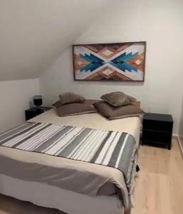 a bed in a bedroom with a painting on the wall at Comptoir du Golf Studio in Villedieu-sur-Indre