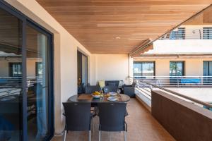 an indoor patio with a table and chairs on a balcony at El Teide Apartment with Pool & Balcony in Puerto de Santiago