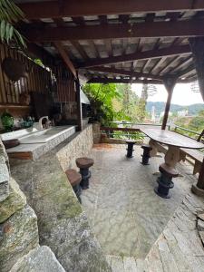 a stone patio with a table and a bath tub at Casa da Oma in Blumenau