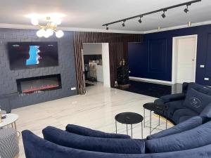 a living room with blue furniture and a fireplace at Casa Bella in Frăteşti