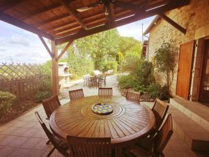 a wooden table and chairs on a patio at 3 self-contained gites with pool and games room in Saint-Georges-de-Noisné