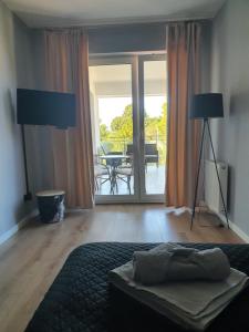 a bedroom with a bed and a view of a patio at Mazury Home Apartament in Giżycko