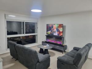 アッコにあるApartment overlooking the seaのソファ2脚と薄型テレビのあるリビングルーム