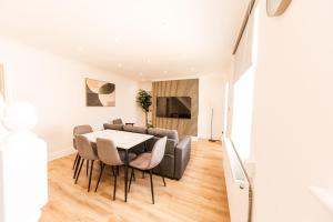 Un comedor y una sala de estar con mesa y sillas. en 3BR Modern Stay - Wi-Fi & Parking, en Monkwearmouth
