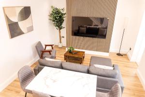 una sala de estar con un sofá y una mesa en 3BR Modern Stay - Wi-Fi & Parking, en Monkwearmouth
