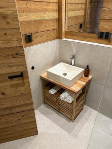 a bathroom with a white sink and wooden walls at Apartment Orol view of the Tatras with a private sauna in Svit