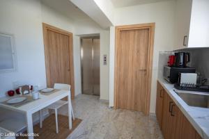 cocina con mesa blanca y microondas en Rodos Suites on the Park, en Rodas