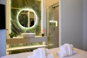 ein Badezimmer mit Waschbecken, Spiegel und Handtüchern in der Unterkunft Antinous Suites in Rom + 48 Fotos