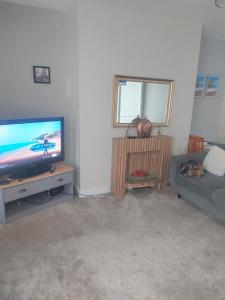 ein Wohnzimmer mit einem TV und einem Sofa in der Unterkunft Maritimum House in Westoe + 5 Fotos