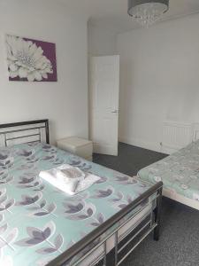 ein Schlafzimmer mit zwei Betten und einem Gemälde an der Wand in der Unterkunft Maritimum House in Westoe