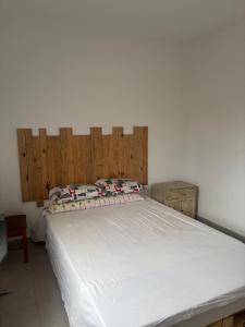 a bedroom with a large white bed with a wooden headboard at Appartement Dakar Dieuppeul in Dakar