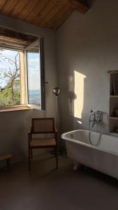 Un baño con bañera, silla y ventana. en Casa Cunicchio, en SantʼElpidio a Mare