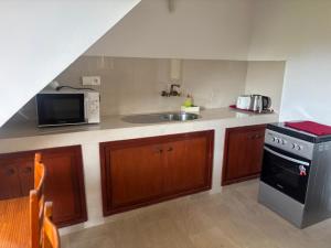 a kitchen with a sink and a stove and a microwave at Appartement Dakar Dieuppeul in Dakar