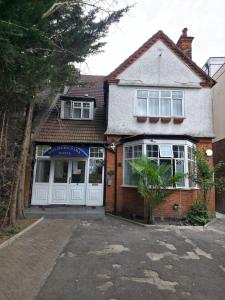a brick house with white doors and a garage at Golders Park Hotel in London