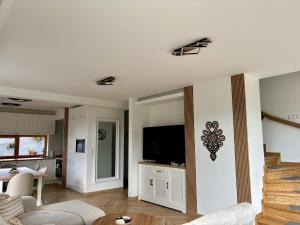 Una sala de estar con un sofá y un televisor en una pared. en Villa Koscielisko, en Kościelisko