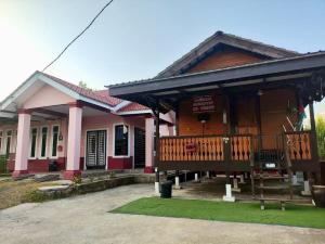 a wooden house with a porch and a balcony at Bushriah Homestay Q Pendang in Pendang