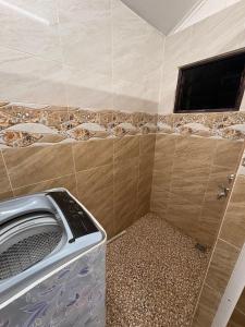 a bathroom with a washing machine and a tv at Bushriah Homestay Q Pendang in Pendang +10 photos