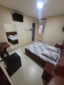 a small bedroom with a bed and a tv in it at hotel royal brás in São Paulo