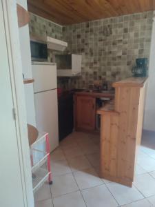 a small kitchen with a refrigerator and a counter at 3p montagnard proche activité in La Colmiane +9 photos