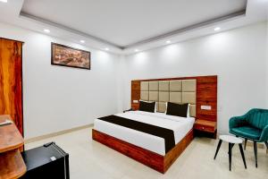a bedroom with a bed and a desk and a chair at Super Collection O Hotel Evergreen in Faridabad