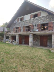 a large stone house with a balcony and a yard at 3p montagnard proche activité in La Colmiane