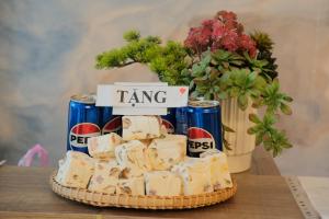 a cake sitting on a table with cans of pepsi at Alphan Hotel in Vạn Ninh