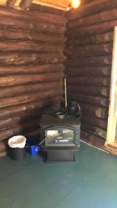 a wood stove in a room with a log wall at Le Shed - 2 personnes in Saint-Siméon