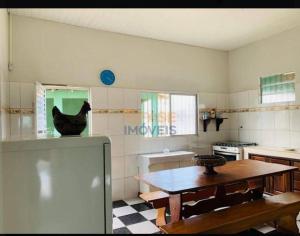 a kitchen with a table and a chicken on the wall at Casa COP 30 BELÉM-Mosqueiro in Belém
