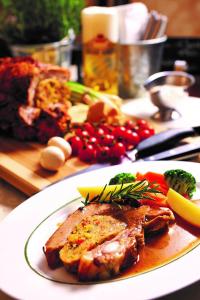 a plate of food with meat and vegetables on a table at Rottaler Stuben in Bad Birnbach