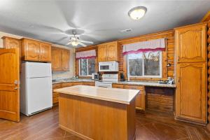 a kitchen with wooden cabinets and a white refrigerator at Evy's Family Ranch Cabin Secluded in Heber City +26 photos