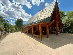 a large log cabin with a bench in front of it at Evy's Family Ranch Cabin Secluded in Heber City