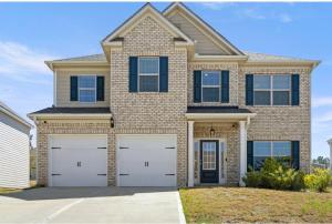 a house with two garage doors in front of it at Conyers Place in Conyers