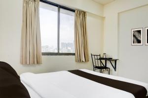 Un dormitorio con una cama y una mesa y una ventana. en Hotel O Destination 41, en Pune 21 fotos más