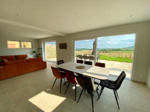 a living room with a table and chairs and a couch at L'horizon des vignes in Itterswiller