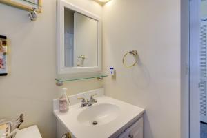 un bagno bianco con lavandino e specchio di Sunny Ocean City Retreat about Qtr-Mi to Beach! a Ocean City Altre 26 foto