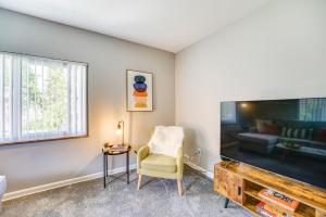 a living room with a chair and a large tv at Pet-Friendly Wyandotte Apt Near Bishop Park! in Wyandotte