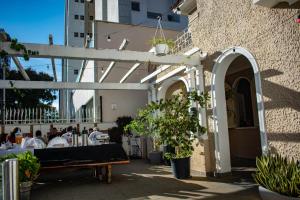 an outdoor patio with a bench and potted plants at Nuhh Hostel & Café in Belo Horizonte