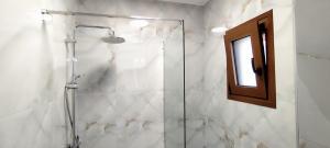 Un baño con ducha con puerta de cristal. en Δίκταμο, en Mouzákion 22 fotos más