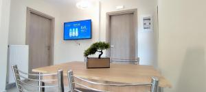 Un comedor con una mesa con sillas y un televisor. en Δίκταμο, en Mouzákion