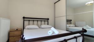 Un dormitorio con dos camas con almohadas blancas y un espejo. en Δίκταμο, en Mouzákion